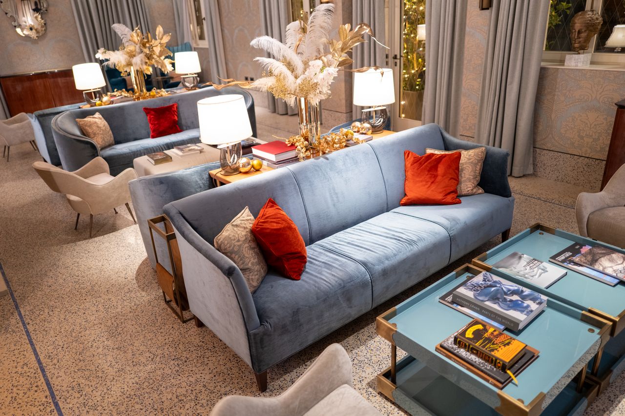 our-story Luxury living room with blue sofas, elegant decor, and stylish lighting creating a cozy ambiance.