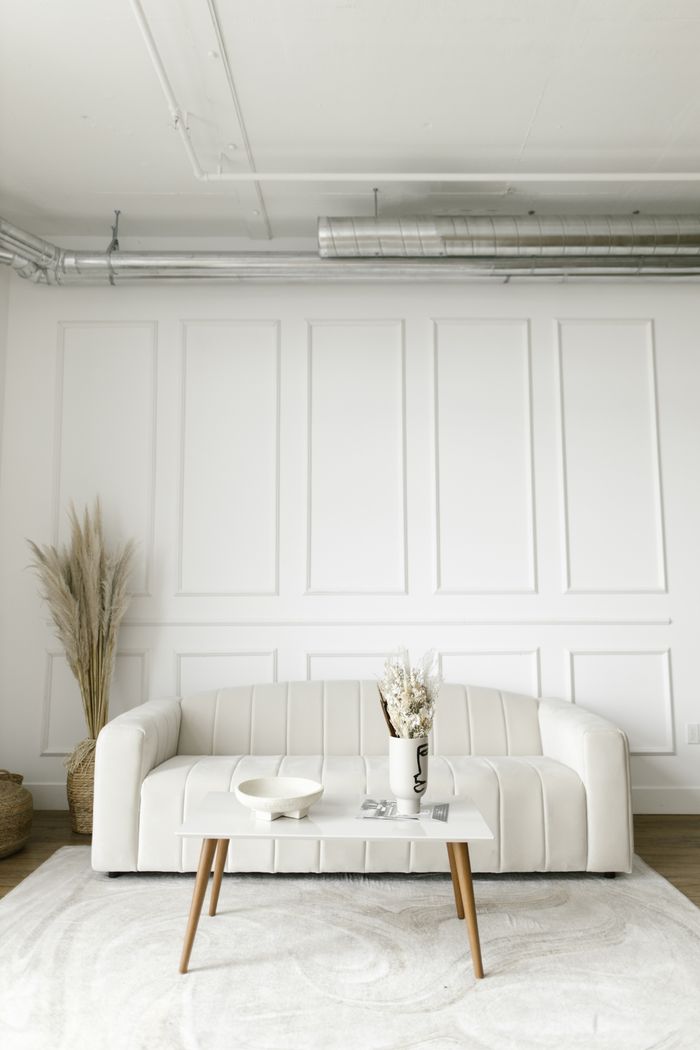 services-02 A bright and modern living room with a white sofa and stylish decor, emphasizing minimalism.